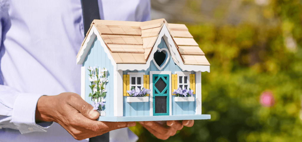 real estate agent holding a house miniature
